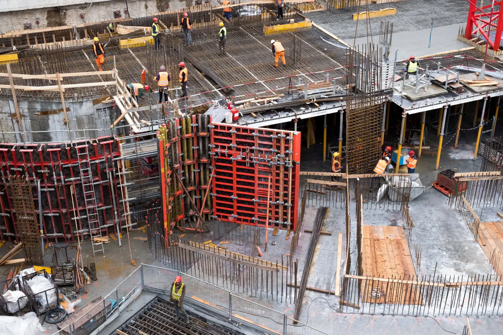 Industrial construction site with workers in safety clothing and steel structures
